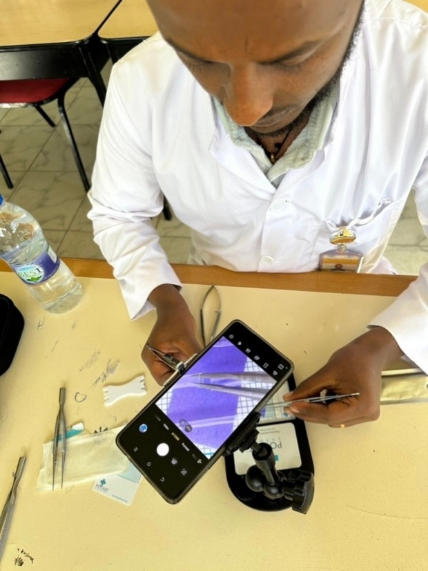 A stuent films their suturing using a smartphone stand