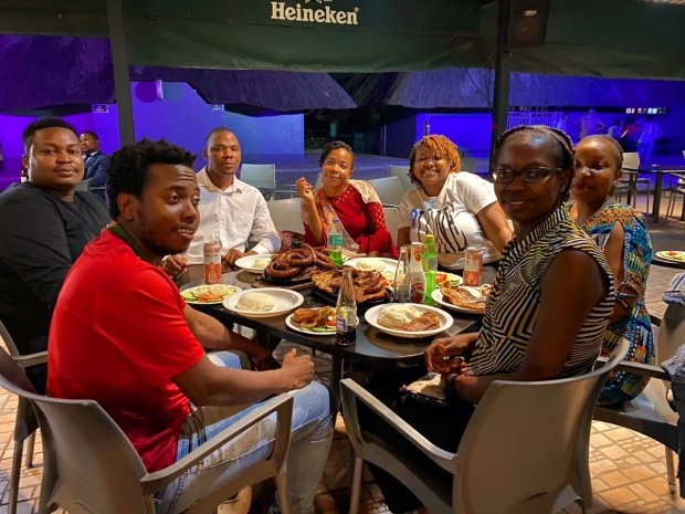 Dr. Ngongoni eats with colleagues in Zimbabwe.