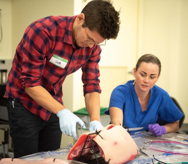 An intern practices putting in a chest tube.
